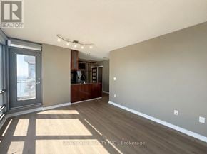 Toronto (Waterfront Communities) condo for rent - A spacious room with wooden flooring and a large window.