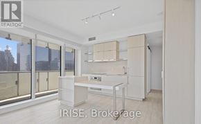 Toronto (Church-Yonge Corridor) condo for rent - A modern kitchen with white cabinets and a large window overlooking the city.