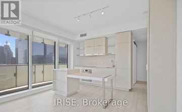 Toronto (Church-Yonge Corridor) condo for rent - A modern kitchen with white cabinets and a large window overlooking the city.