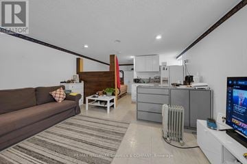 Toronto (Willowdale West) apartment for rent - A living room with a brown couch and a television on a white stand.