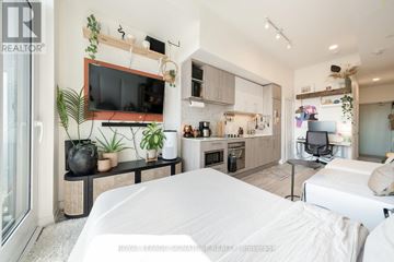 Toronto (Humewood-Cedarvale) condo for rent - A modern living room with a white couch and a television on the wall.