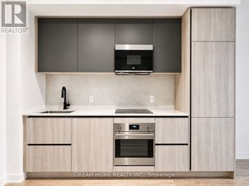Toronto (Waterfront Communities) condo for rent - A modern kitchen with wooden cabinets and stainless steel appliances.
