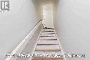Toronto (Niagara) townhouse for rent - A white hallway with a staircase and a logo for Royal LePage Signature Realty in Brokerage.