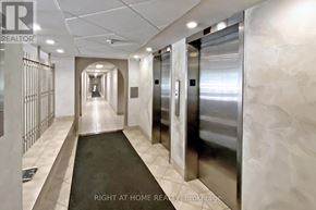 Toronto (Tam O'shanter-Sullivan) condo for rent - A hallway with a metal elevator and a sign that says "Right at Home REALTY Brokerage".