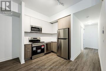 Toronto (Oakridge) townhouse for rent - A kitchen with a stainless steel refrigerator and microwave.