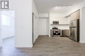Toronto (Oakridge) townhouse for rent - A kitchen area with a refrigerator, microwave, and oven.