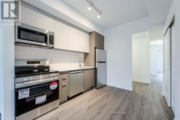 Toronto (Oakridge) townhouse for rent - A kitchen with a stove top oven and microwave above it.