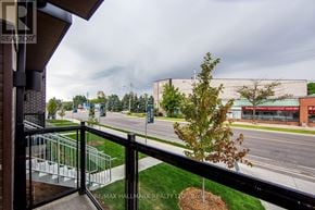 Toronto (Oakridge) townhouse for rent - A view from a balcony overlooking a street with a building in the distance.