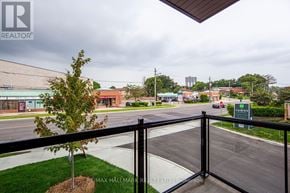 Toronto (Oakridge) townhouse for rent - A view from a balcony overlooking a street with a sign that reads "TOWNS".