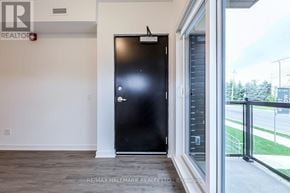 Toronto (Oakridge) townhouse for rent - A black door in a room with a window on the right side.