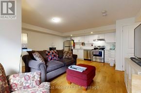 Clarington (Bowmanville) townhouse for rent - A living room with a grey couch and a red ottoman.
