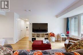 Clarington (Bowmanville) townhouse for rent - A living room with a couch, a television, and a window.