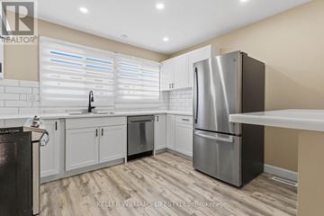 London North (North I) townhouse for rent - A modern kitchen with a stainless steel refrigerator and white cabinets.