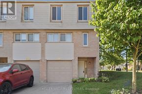 London North (North I) townhouse for rent - A red car is parked in front of a house with a tree to the right.