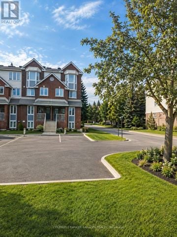 Ottawa townhouse for rent - A large brick building with a tree in front of it.
