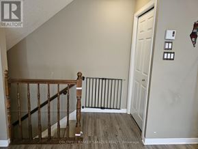 Ottawa townhouse for rent - A hallway with a white door and a wooden staircase.