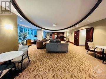 Ottawa condo for rent - A living room with a patterned carpet and a large window.