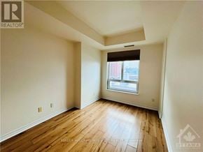 Ottawa condo for rent - A room with wooden flooring and a window with blinds.