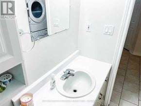 Barrie (Northwest) apartment for rent - A small white bathroom with a washer and dryer built into the wall.