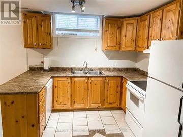Barrie (Northwest) apartment for rent - A kitchen with wooden cabinets and a granite countertop.