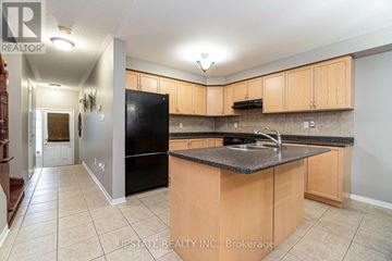 Brampton (Bram East) apartment for rent - A kitchen with wooden cabinets and a black refrigerator.
