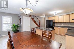 Brampton (Bram East) apartment for rent - A dining room with a wooden table and chairs.