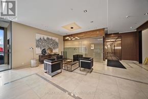 Toronto (Islington-City Centre West) condo for rent - A modern lobby with a glass wall and a large artwork on the wall.