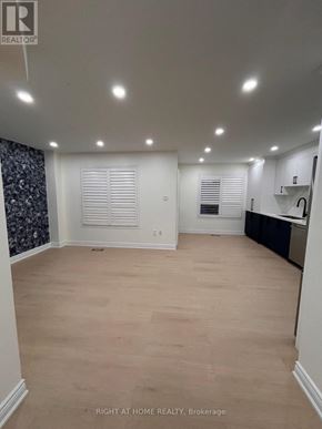 Mississauga (Churchill Meadows) apartment for rent - A spacious room with wooden flooring and white walls.