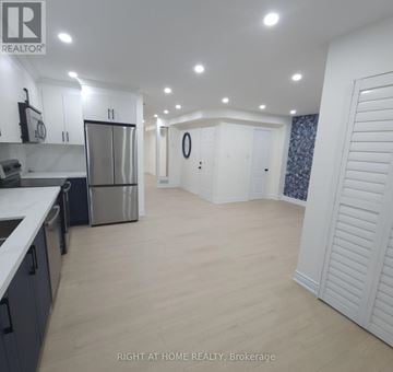 Mississauga (Churchill Meadows) apartment for rent - A spacious kitchen and living room with white cabinets and a large island.