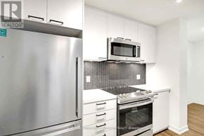 Toronto (Weston-Pellam Park) condo for rent - A modern kitchen with stainless steel appliances and white cabinets.