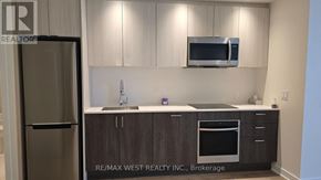 Toronto (South Parkdale) condo for rent - A kitchen with a refrigerator, microwave, and oven.