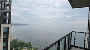 Toronto (South Parkdale) condo for rent - A balcony overlooks a body of water with a cityscape in the distance.