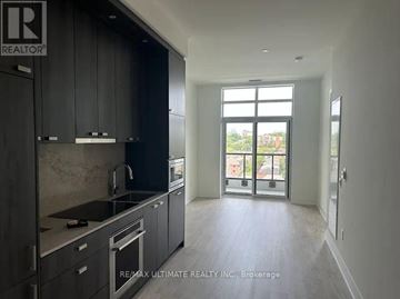 Toronto (Junction Area) condo for rent - A modern kitchen with dark cabinets and stainless steel appliances.