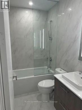 Toronto (Junction Area) condo for rent - A white toilet is in a bathroom with a marble wall.