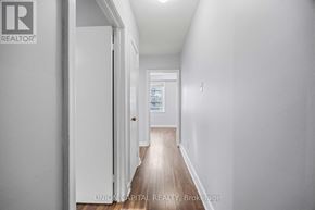Toronto (Briar Hill-Belgravia) apartment for rent - A hallway with a door on the left and a window on the right.