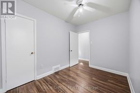 Toronto (Briar Hill-Belgravia) apartment for rent - A room with wood flooring and white walls, with a ceiling fan and two doors.