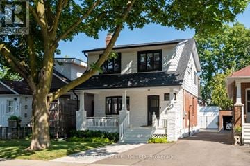 Toronto (Weston) apartment for rent - A white house with a black roof and a tree in front.