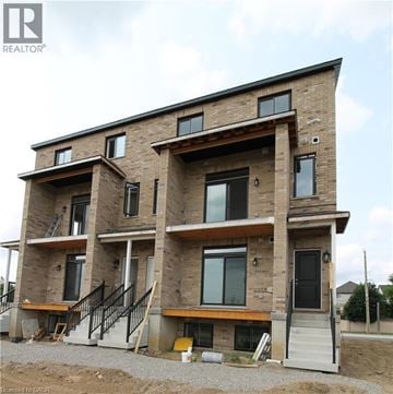 Kitchener townhouse for rent - A large, multi-story residential building under construction with visible wooden beams and brickwork.