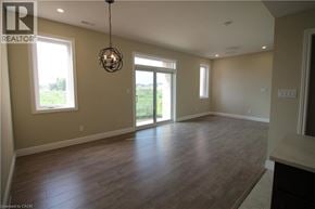 Kitchener townhouse for rent - A large empty room with wooden floors and a chandelier.