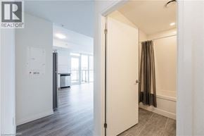 Kitchener condo for rent - A white door with a black handle is open to a room with a grey carpet.