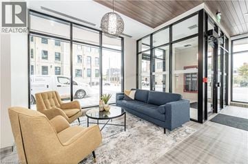 Kitchener condo for rent - A living room with a blue couch and a glass table.