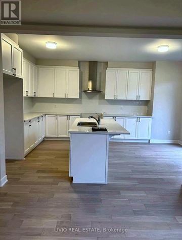 Ottawa apartment for rent - A kitchen with white cabinets and a wooden floor.