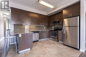 Waterloo townhouse for rent - A kitchen with brown cabinets and stainless steel appliances.
