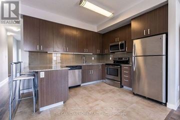Waterloo townhouse for rent - A kitchen with brown cabinets and stainless steel appliances.