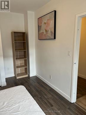 Waterloo townhouse for rent - A bedroom with a bed, a shelf, and a painting on the wall.