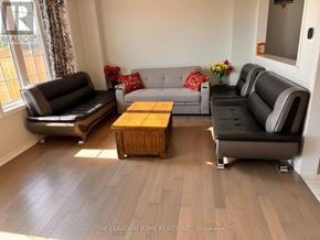 Thorold (Hurricane/Merrittville) apartment for rent - A living room with a grey couch, black leather couch, and a wooden coffee table.