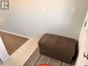 Thorold (Hurricane/Merrittville) apartment for rent - A brown ottoman is on a striped rug in a room.