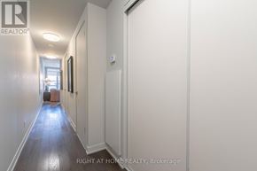 Toronto (Dufferin Grove) condo for rent - A long hallway with a brokerage sign on the wall.