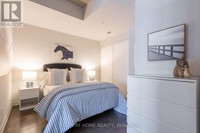 Toronto (Dufferin Grove) condo for rent - A bedroom with a bed, nightstands, and a painting on the wall.