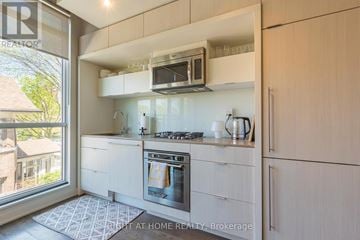 Toronto (Dufferin Grove) condo for rent - A modern kitchen with a stove top oven and a microwave above it.